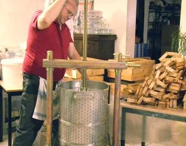 Bernard en train de presser le miel au pressoir à miel